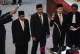 Anggota DPR HM Gandung Pardiman (kedua kiri), Maman Abdurahman (tengah) dan Jerry Sambuaga (kedua kanan) mengucap sumpah jabatan saat dilantik pada Rapat Paripurna DPR di Kompleks Parlemen Senayan, Jakarta, Kamis (26/7/2018). Rapat Paripurna DPR melantik tiga orang anggota dewan Pengganti Antarwaktu (PAW) dari Fraksi Golkar. (ANTARA FOTO/Dhemas Reviyanto) 