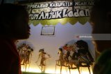 Pengunjung mengamati wayang Timplong khas Nganjuk saat pameran seni budaya panji di area Simpang Lima Gumul, Kediri, Jawa Timur, Senin (9/7) malam. Sejumlah seni tradisional adaptasi dari Cerita Panji dipamerkan guna mengingatkan budaya leluhur kepada masyarakat khususnya generasi muda. Antara Jatim/Prasetia Fauzani/zk/18