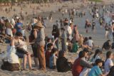 Wisatawan domestik dan mancanegara memadati kawasan wisata Pantai Kuta, Badung, Bali, Jumat (6/7/2018). Menurut Asosiasi Perusahaan Perjalanan Wisata Indonesia (ASITA) Bali, kondisi pariwisata di Pulau Dewata tetap aman dan tidak terdampak aktivitas vulkanik Gunung Agung yang terus mengalami erupsi. (ANTARA FOTO/Fikri Yusuf)