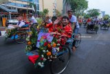 Peserta parade lintas budaya mengikuti pawai becak di Surabaya, Jawa Timur, Minggu (15/7). Kegiatan itu merupakan rangkaian Surabaya Cross Culture International Folk and Art Festival 2018 yang diikuti oleh 10 negara dan tiga kota dari Indonesia. Antara Jatim/Didik Suhartono/mas/18.