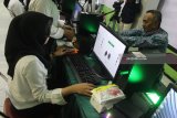 Petugas melayani calon haji untuk perekaman sidik jari dan data biometrik di Asrama Haji Embarkasi Surabaya (AHES), Surabaya, Jawa Timur, Senin (16/7). Perekaman sidik jari dan data biometrik bagi calon haji yang mulai diterapkan di Embarkasi setempat tersebut untuk memudahkan dan mengurangi waktu antre saat tiba di bandara tujuan di Arab Saudi.  Antara jatim/Moch Asim/zk/18.