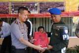 Kapolres Jember AKBP Kusworo Wibowo (kiri), melimpahkan berkas kasus penganiayaan wartawan kepada Sub Detasemen Polisi Militer (Subdenpom) Serma Solihin (kanan), di Mapolres Jember, Jawa Timur, Selasa (10/7). Polres Jember melimpahkan berkas kasus penganiayaan wartawan www.beritajatim.com Oryza A. Wirawan kepada Subdenpom V/3-2 Jember karena dari hasil pemeriksaan saksi-saksi dan video, tidak ditemukan pelaku yang berasal dari unsur sipil. Antara Jatim/Seno/mas/18.