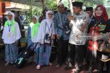 Menteri Agama Lukman Hakim Saifuddin (kedua kanan) berbincang dengan jamaah calon haji disela acara pemberangkatan jamaah calon haji kelompok terbang (kloter) pertama di Asrama Haji Embarkasi Surabaya (AHES), Surabaya, Jawa Timur, Selasa (17/7). Panitia Penyelenggara Ibadah Haji (PPIH) Embarkasi Surabaya memberangkatkan sebanyak 37.055 jamaah calon haji yang terdiri dari 35.270 JCH dari Provinsi Jawa Timur, 700 JCH dari Bali, 670 JCH dari NTT serta 415 petugas pendamping. Antara Jatim/Moch Asim/18