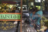 Petugas membantu seorang calon haji saat pemeriksaan barang bawaan jamaah calon haji di Asrama Haji Sukolilo, Surabaya, Jawa TImur, Rabu (18/7). Dari pemeriksaan bawaan calon haji tersebut sejumlah barang-barang disita seperti batu kerikil, gunting, madu dan beberapa benda tajam dan kosmetik lainnya. Antara Jatim/Zabur Karuru/18