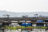 Pekerja melintas di keramba jaring apung saat penertiban di waduk Cirata, Kabupaten Bandung Barat, Jawa Barat, Kamis (19/7). Sebanyak 474 petak keramba jaring apung akan ditertibkan secara berkala hingga Desember 2018. ANTARA JABAR/M Agung Rajasa/agr/18.
