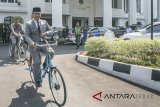 Gubernur Provinsi Jawa Barat terpilih Ridwan Kamil menaiki sepeda usai diperkenalkan pada Rapat Paripurna Istimewa DPRD Jawa Barat di Gedung DPRD Jawa Barat, Bandung, Jawa Barat, Rabu (25/7). DPRD Jawa Barat akan secepatnya mengusulkan surat pengesahan Gubernur dan Wakil Gubernur Jawa Barat tepilih kepada Presiden melalui Mendagri untuk Pelantikan Gubernur dan Wakil Gubernur Jawa Barat Periode 2018-2023. ANTARA JABAR/Novrian Arbi/agr/18