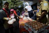 Warga menukarkan kupon saat bazar pangan murah di Kantor Dinas Pertanian dan Ketahanan Pangan, Bandung Jawa Barat, Senin (23/7). Bazar pangan murah yang diselenggarakan oleh Bank Indonesia, Bulog, bjb dan TPID tersebut menyediakan 500 kilogram telor ayam seharga Rp23.800 per kilogram, dan 1.000 ekor ayam beku dengan harga Rp33.000 per ekor guna mengendalikan harga ayam dan telur yang melejit di pasaran. ANTARA JABAR/Raisan Al Farisi/agr/18.