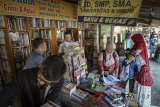 Seorang ibu menawarkan buku kepada anaknnya di sentra penjualan buku di Palasari, Bandung, Jawa Barat, Jumat (6/7). Pedagang menyatakan menjelang tahun ajaran baru 2018/2019 penjualan buku mata pelajaran SD, SMP dan SMA di sentra tersebut meningkat 10 persen dibandingkan dengan hari biasanya. ANTARA JABAR/Raisan Al Farisi/agr/18