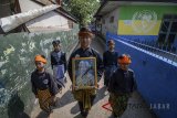 Sejumlah anak membawa foto saat prosesi upacara dalam rangka memperingati 100 tahun Nelson Mandela di Lio Genteng, Bandung, Jawa Barat, Minggu (29/7). Sekolah Rakyat Iboe Inggit Garnasih menggelar prosesi upacara untuk mengenang tokoh gerakan anti Apartheid di Afrika Selatan yang lahir pada 18 Juli 1918, Nelson Mandela. ANTARA JABAR/Raisan Al Farisi/agr/18