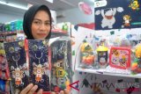 Penjaga toko menunjukkan pernak pernik Asian Games 2018 di salah satu minimarket di Kota Bogor, Jawa Barat, Senin (16/7/2018). Pernak pernik itu dijual dengan harga Rp14.000 hingga Rp80.000 untuk menyemarakkan ajang Asian Games 2018 sekaligus mendukung pemberdayaan ekonomi rakyat karena pembuatannya melibatkan UMKM. (ANTARA /Arif Firmansyah) 