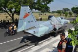 Warga menyaksikan pesawat tempur ‘F-5 Tiger’ saat tiba di Alun-alun Kabupaten Madiun, Jawa Timur, Kamis (12/7). TNI AU menghibahkan pesawat ‘F-5 Tiger’ nomor TS 0513 kepada Pemkab Madiun untuk pendirian monumen. Pesawat tersebut sebelumnya selama 35 tahun dioperasikan Skadron Udara 14 Lanud Iswahjudi Magetan, Jawa Timur, dan sejak 2016 dinyatakan ‘grounded’ (tidak diperbolehkan terbang).  Antara Jatim/Siswowidodo/mas/18.