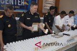 Perwakilan Australia Border Force, Chris Waters (kedua kiri) bersama petugas Bea Cukai Ngurah Rai dan dan Badan Narkotika Nasional (BNN) memeriksa barang bukti berupa botol kemasan berisi bahan pembuatan sabu-sabu (prekursor) yaitu hasil penyitaan barang kiriman saat konferensi pers di Kantor Bea Cukai Ngurah Rai, Denpasar, Senin (16/7). Bea Cukai Ngurah Rai bekerja sama dengan Australia Border Force menggagalkan pengiriman 600.000 pil mengandung Pseudoephedrine (bahan pembuatan sabu-sabu) dari Korea Selatan, transit di Bali dan rencananya menuju Australia. Antaranews Bali/Nyoman Budhiana/2018.