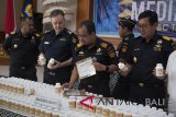 Direktur Jenderal Bea dan Cukai, Heru Pambudi (ketiga kanan) bersama perwakilan Australia Border Force, Chris Waters (kedua kiri) memeriksa barang bukti berupa botol kemasan berisi bahan pembuatan sabu-sabu (prekursor) yaitu hasil penyitaan barang kiriman saat konferensi pers di Kantor Bea Cukai Ngurah Rai, Denpasar, Senin (16/7). Bea Cukai Ngurah Rai bekerja sama dengan Australia Border Force menggagalkan pengiriman 600.000 pil mengandung Pseudoephedrine (bahan pembuatan sabu-sabu) dari Korea Selatan, transit di Bali dan rencananya menuju Australia. Antaranews Bali/Nyoman Budhiana/2018.