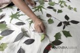 Perajin mengerjakan pembuatan batik cetak daun di galeri Fashion Ecoprint Jumiko, Cilebut, Kabupaten Bogor, Jawa Barat, Rabu (11/7). Produksi batik cetak daun berbahan dasar dari alam tersebut dijual dengan kisaran harga Rp250 ribu-Rp.1,5 juta dan telah menembus pasar Eropa dan Amerika. ANTARA JABAR/Yulius Satria Wijaya/agr/18.