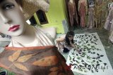 Perajin mengerjakan pembuatan batik cetak daun di galeri Fashion Ecoprint Jumiko, Cilebut, Kabupaten Bogor, Jawa Barat, Rabu (11/7). Produksi batik cetak daun berbahan dasar dari alam tersebut dijual dengan kisaran harga Rp250 ribu-Rp.1,5 juta dan telah menembus pasar Eropa dan Amerika. ANTARA JABAR/Yulius Satria Wijaya/agr/18.