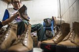 Pekerja menyelesaikan pembuatan sepatu kulit Sneaker di industri kecil dan menengah (IKM) Exodos 57 di Bandung, Jawa Barat, Selasa (17/7). Dalam sebulan IKM tersebut dapat memproduksi sepatu hingga 500 pasang untuk memenuhi pasar Indonesia serta luar negeri yang di bandrol mulai dari harga Rp 300 ribu hingga Rp 800 rb per pasang. ANTARA JABAR/M Agung Rajasa/agr/18.
