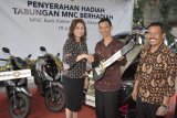 EVP, Retail Funding Business Head MNC Bank, Rita Montagna (kiri) dan Pimpinan Cabang MNC Bank Denpasar, I Ketut Yadnyana (kanan) menyerahkan hadiah kepada nasabah penerima saat kegiatan penyerahan Tabungan MNC Berhadiah di Denpasar, Bali, Kamis (19/7). Program Tabungan MNC Berhadiah tersebut digelar sebagai bentuk apresiasi terhadapi kepercayaan nasabah sekaligus untuk meningkatkan komposisi dana murah (CASA). ANTARA FOTO/Fikri Yusuf/18