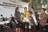 EVP, Retail Funding Business Head MNC Bank, Rita Montagna (kiri) dan Pimpinan Cabang MNC Bank Denpasar, I Ketut Yadnyana (kanan) menyerahkan hadiah kepada nasabah penerima saat kegiatan penyerahan Tabungan MNC Berhadiah di Denpasar, Bali, Kamis (19/7). Program Tabungan MNC Berhadiah tersebut digelar sebagai bentuk apresiasi terhadapi kepercayaan nasabah sekaligus untuk meningkatkan komposisi dana murah (CASA). ANTARA FOTO/Fikri Yusuf/18