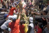 Warga berebut gunungan tumpeng berisi aneka hasil bumi dalam ritual ruwatan Alas Kandung di area wisata konservasi hutan lindung Kandung, Rejotangan, Tulungagung, Jawa Timur, Minggu (22/7). Ruwatan alas kandung merupakan tradisi tasyakuran sedekah bumi tiap bulan Selo dalam penanggalan Jawa yang terus dijaga warga setempat untuk menumbuhkan kesadaran lingkungan menjaga hutan Alas Kandung. Antara Jatim/Destyan Sujarwoko/zk/18