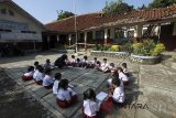 Sejumlah siswa mengikuti proses belajar di ruang terbuka saat bangunan sekolah yang roboh tak kunjung diperbaiki di SDN Kotabatu 08, Kabupaten Bogor, Jawa Barat, Senin (23/7). Dua bangunan ruang kelas di sekolah tersebut ambruk sejak Mei 2018 dan tak kunjung diperbaiki hingga mengganggu proses belajar. ANTARA JABAR/Yulius Satria Wijaya/agr/18.