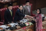 Menteri Keuangan Sri Mulyani (kanan) memberikan hasil tanggapan pemerintah kepada Ketua Sidang Utut Adianto (kedua kiri), disaksikan Ketua DPR Bambang Soesatyo (kiri) dan Wakil Ketua DPR Fahri Hamzah pada Sidang Paripurna DPR di Komplek DPR, Jakarta, Selasa (17/7/2018). Paripurna tersebut beragendakan mendengarkan tanggapan pemerintah terhadap pandangan fraksi-fraksi atas keterangan pemerintah mengenai Pokok-Pokok Rancangan Undang-Undang tentang pertanggungjawaban atas pelaksanaan Anggaran Pendapatan dan Belanja Negara Tahun Anggaran 2017. (ANTARA FOTO/Muhammad Adimaja)