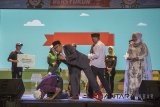 Seorang warga melakukan sujud syukur saat diberi hadiah oleh Gubernur Provinsi Jawa Barat terpilih, Ridwan Kamil (tengah) saat acara Rindu Bersyukur di Gedung Sasana Budaya Ganesha, Bandung, Jawa Barat, Minggu (22/7).  Acara tersebut bertujuan untuk silaturahmi sekaligus ucapan rasa syukur pasangan Ridwan Kamil-UU Ruzhanul Ulum kepada masyarakat, partai pendukung dan simpatisan atas terpilih sebagai Gubernur dan Wakil Gubernur Provinsi Jawa Barat periode 2018-2023 pada Pilkada 2018 beberapa waktu lalu. ANTARA JABAR/Novrian Arbi/agr/18