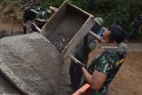 Prajurit TNI membuat rabat beton jalan dalam kegiatan TNI Manunggal Membangun Desa (TMMD) di Desa Bodag, Kecamatan Kare, Kabupaten Madiun, Jawa Timur, Kamis (19/7). Pembuatan rabat beton jalan sepanjang 1.462 meter dengan lebar tiga meter di kawasan objek wisata bukit Selo Gedong di lereng Gunung Wilis tersebut merupakan salah satu dari sejumlah program kegiatan dalam TMMD ke-102 tahun 2018 di Kabupaten Madiun. Antara Jatim/Siswowidodo/mas/18.