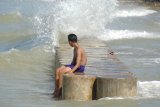 Seorang anak bermain didekat tanggul penahan ombak di Pantai Jumiang, Pamekasan, Jawa Timur, Kamis (12/7). Badan Meteorologi Klimatologi dan Geofisika (BMKG) memberikan peringatan untuk mewaspadai tinggi gelombang 0.75 m hingga lebih dari 3.0 m terutama di Perairan selatan Jatim dan Samudra Hindia selatan Jatim. Antara Jatim/Saiful Bahri/mas/18.