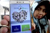 Warga menunjukan aplikasi digital milik Badan Penyelenggara Jaminan Sosial (BPJS) Kesehatan saat sosialisasi di Kabupaten Bogor, Jawa Barat, Senin (30/7). BPJS Kesehatan menargetkan pada 1 Januari 2019 minimal 95 persen penduduk Indonesia tercakup layanan Jaminan Kesehatan Nasional-Kartu Indonesia Sehat (JKN-KIS). ANTARA JABAR/Yulius Satria Wijaya/agr/18.