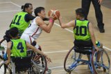 Pebasket kursi roda Indonesia Donald Putra Santoso (tengah) berebut bola dengan pebasket Malaysia Fazlan Ismail (kiri) dan Nor Muhammad Firdaus pada Indonesia Para Games Invitational Tournament di Kompleks Gelora Bung Karno, Senayan, Jakarta, Minggu (1/7/2018). Tim bola basket kursi roda Indonesia menang atas Malaysia dengan skor 54-53. (ANTARA FOTO/Wahyu Putro A)