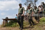 Komandan Pusat Teritorial Mabes TNI Angkatan Darat (Danpusterad Mabesad) Mayjen TNI Hartomo (kiri) menuruni bukit saat meninjau kegiatan TNI Manunggal Membangun Desa (TMMD) di Desa Bodag, Kecamatan Kare, Kabupaten Madiun, Jawa Timur, Kamis (19/7). Mayjen TNI Hartomo meninjau sejumlah kegiatan TMMD, antara lain pembangunan Rumah Tidak Layak Huni (RTLH), pembuatan jalan rabat beton menuju objek wisata Selo Gedong di lereng Gunung Wilis, pengobatan gratis dan wawasan kebangsaan. Antara Jatim/Siswowidodo/mas/18.