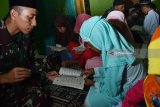 Prajurit TNI mengajar mengaji anak-anak di masjid Desa Bodag, Kecamatan Kare, Kabupaten Madiun, Jawa Timur, Senin (23/7) malam. Kegiatan tersebut merupakan bagian dari program TNI Manunggal Membangun Desa (TMMD) ke-102 tahun 2018 di Kabupaten Madiun. Antara Jatim/Siswowidodo/zk/18