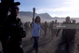 Lagenda bulu tangkis Indonesia Susi Susanti (tengah) berlari sambil membawa obor Asian Games 2018 saat prosesi Torch Relay Asian Games 2018 di lautan pasir Gunung Bromo, Probolinggo, Jawa Timur, Sabtu (21/7).  Selanjutnya pawai obor Asian Games tersebut akan dibawa ke  Banyuwangi, Jawa Timur. ANTARA FOTO/Zabur Karuru/18