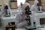 Mahasiswi D3 jurusan Analis Kesehatan Universitas Muhammadiyah Surabaya (UMS) mengamati jamur melalui mikroskop saat mengikuti ujian praktik Mikologi di laboratorium biomedik di Surabaya, Jawa Timur, Selasa (10/7). Ujian akhir semester tersebut untuk mempelajari berbagai macam tentang jamur yang menyebabkan penyakit pada manusia. Antara Jatim/Moch Asim/18.