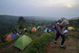 Suasana tenda wisatawan yang memadati wisata alam Bukit Alesano di Desa Cipelang, Kabupaten Bogor, Jawa Barat, Minggu (22/7). Bukit Alesano yang terletak di lembah Gunung Salak dengan ketinggian 600 meter di atas permukaan laut tersebut menawarkan panorama alam dengan latar belakang Gunung Gede Pangrango yang menjadi alternatif wisata di Kabupaten Bogor. ANTARA JABAR/Raisan Al Farisi/agr/18.