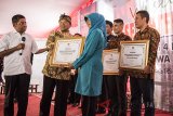 Menteri Sosial Idrus Marham (kiri) didampingi Bupati Bandung Dadang M Naser (kedua kiri) memberikan penghargaan kepada perwakilan desa yang menerima penghargaan saat wisuda Desa Sejahtera Mandiri di Ciburial, Kabupaten Bandung, Jawa Barat, Kamis (12/7). Sebanyak delapan desa dari empat kabupaten di Jawa Barat diberikan penghargaan dan diresmikan sebagai Desa Sejahtera Mandiri sebagai upaya percepatan penanganan kemiskinan terpadu. ANTARA JABAR/M Agung Rajasa/agr/18.
