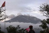 Warga mengamati asap yang mengepul dari kawah Gunung Agung di Pos Pemantauan Gunungapi Agung, Rendang, Karangasem, Bali, Selasa (3/7). Pusat Vulkanologi dan Mitigasi Bencana Geologi (PVMBG) mencatat pada Selasa (3/7) hingga pukul 18.00 WITA, terjadi tiga kali letusan Gunung Agung yang mengeluarkan asap kawah berwarna putih dan kelabu setinggi hingga 2.000 meter. ANTARA FOTO/Fikri Yusuf/wdy/2018