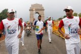 Mantan pemain tim hoki India Sardar Singh (tengah) membawa obor Asian Games 2018 di depan Gerbang India di New Delhi, India, Minggu (15/7). ANTARA FOTO/REUTERS/Adnan Abidi/cfo/aww/18. 