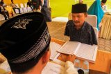 Penyandang disabilitas Rahmatsyah, bakal calon Legislatif (bacaleg) mengikuti uji baca Alquran di Lhokseumawe, Aceh, Jumat (20/7). Bacaleg yang tidak memiliki kedua tangan (cacat sejak lahir) tersebut merupakan perwakilan kaum disabilitas yang diusung Partai Berkarya yang membawa aspirasi hak yang sama untuk 3000 lebih penyandang disabilitas ke kursi parlemen di kabupaten itu. (ANTARA FOTO/Rahmad/ama/18)