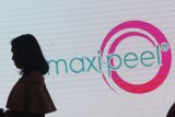 Pengunjung berdiri di depan tulisan Maxi-Peel saat acara peluncuran produk 