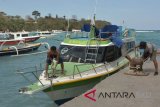 Sejumlah pekerja beraktivitas di Pelabuhan Padangbai, Karangasem, Bali, Senin (30/7). Aktivitas penyeberangan kapal cepat dari pelabuhan tersebut menuju sejumlah wilayah ditutup hingga Selasa (31/7) atau hingga keadaan cuaca membaik, akibat terjadinya gelombang tinggi hingga 2,5 meter dan kecepatan angin hingga 15 knot. ANTARA FOTO/Fikri Yusuf/wdy/2018.