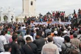 Pengunjukrasa yang tergabung dalam Koalisi Masyarakat Aceh Bersatu (KMBA) membawa spanduk dan poster saat menggelar aksi di kawasan Masjid Raya Baiturrahman, Banda Aceh, Senin (9/7). Aksi damai yang digelar Koalisi Masyarakat Aceh Bersatu (KMBA) itu menuntut Presiden Joko Widodo dan Komisi Pemberantasan Korupsi (KPK) segera membebaskan Gubernur Aceh, Irwandi Yusuf yang sudah ditetapkan sebagai tersangka dalam kasus dugaan korupsi demi perdamaian di Aceh. (ANTARA FOTO/Ampelsa/ama/18)