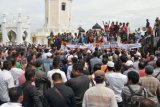 Pengunjukrasa yang tergabung dalam Koalisi Masyarakat Aceh Bersatu (KMBA) membawa spanduk dan poster saat menggelar aksi di kawasan Masjid Raya Baiturrahman, Banda Aceh, Senin (9/7/2018). Aksi damai yang digelar Koalisi Masyarakat Aceh Bersatu (KMBA) itu menuntut Presiden Joko Widodo dan Komisi Pemberantasan Korupsi (KPK) segera membebaskan Gubernur Aceh, Irwandi Yusuf yang sudah ditetapkan sebagai tersangka dalam kasus dugaan korupsi demi perdamaian di Aceh. (ANTARA /Ampelsa) 