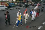 Sejumlah atlet peraih medali saat Peparnas XV Jawa Barat melakukan aksi jalan kaki menuju Jakarta di Bandung, Jawa Barat, Sabtu (4/8). Enam atlet paralimpik tersebut melakukan aksi berjalan kaki menuju Gelora Bung Karno dan berencana mengembalikan medali emas dan perak yang diraih saat Peparnas XV kepada Presiden Indonesia karena masih menggantungnya kasus pemotongan bonus dan wajib setor 25 persen ke National Parlympic Comitte Indonesia Pusat dan Jawa Barat. ANTARA JABAR/Novrian Arbi/agr/18