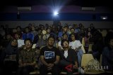 Puluhan penyandang tunanetra bersama 'visual reader' menyaksikan film Ada Apa Dengan Cinta 2 saat mengikuti acara Bioskop Harewos di Bandung, Jawa Barat, Minggu (12/8). Bioskop 'harewos' (berbisik) yang diikuti oleh 36 tunanetra dan 36 visual reader tersebut ditujukan untuk memberikan sensasi menonton film bioskop kepada tunanetra dengan cara mempertemukan mereka dengan orang baru di luar lingkungannya. ANTARA JABAR/Raisan Al Farisi/agr/18.