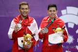 Pebulu tangkis ganda putra Indonesia peraih medali perak Muhammad Rian Ardianto (kanan) dan Fajar Alfian (kiri) berpose usai upacara penyerahan medali ganda putra Asian Games 2018 di Istora Senayan, Jakarta, Selasa (28/8/2018). (ANTARA FOTO/INASGOC/Nafielah/Mahmudah)