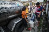 Warga antri untuk mendapatkan distribusi air bersih dari Petugas Badan Penanggulangan Bencana Daerah (BPBD) di Rancamaya, Bogor Selatan, Jawa Barat, Sabtu (18/8). BPBD Kota dan Kabupaten Bogor mendistribusikan sepuluh ribu liter air per hari guna mengantisipasi kekeringan air sumur yang terjadi di beberapa wilayah Bogor. ANTARA JABAR/Raisan Al Farisi/agr/18