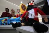 Mahasiswa Universitas Muhammadiyah Surabaya (UMS) memperlihatkan boneka edukatif anak dari limbah daur ulang 