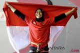 Atlet panjat tebing Indonesia Aries Susanti Rahayu mengibarkan Bendera Merah Putih setelah berhasil meraih medali emas pada kategori speed Asian Games 2018 di Arena Panjat Tebing Jakabaring Sport City, Palembang, Sumatera Selatan, Kamis (23/8/2018). (ANTARA FOTO/INASGOC/Iwan Cheristian)