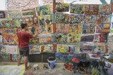 Seorang warga membuat karya seni lukis saat Festival Kampung Kreatif di Dago Pojok, Bandung, Jawa Barat, Selasa (7/8). Festival kampung kreatif yang diadakan hingga 4 September mendatang itu menampilkan 160 karya seni lukis dan instalasi hasil tangan warga yang ditujukan sebagai upaya promosi wisata seni di Kota Bandung. ANTARA JABAR/Raisan Al Farisi/agr/18